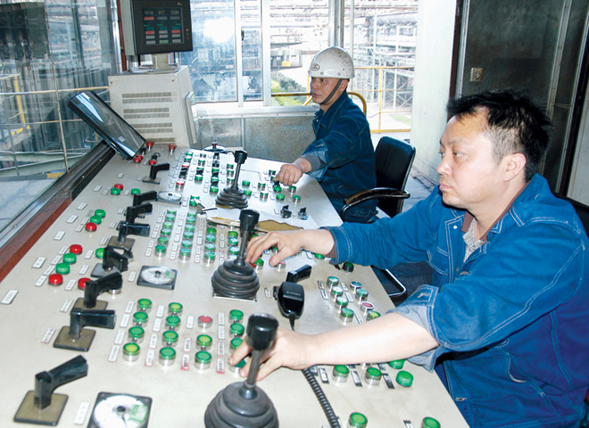 煤化工厂二炼焦车间2号推焦车职工韦尧与班组职工在精心操作