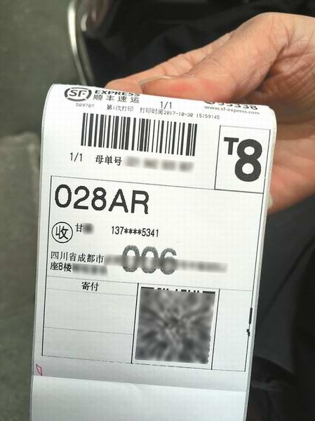 10月30日,在成都市中心一顺丰快递营业部门口,几名快递员正将一堆零散